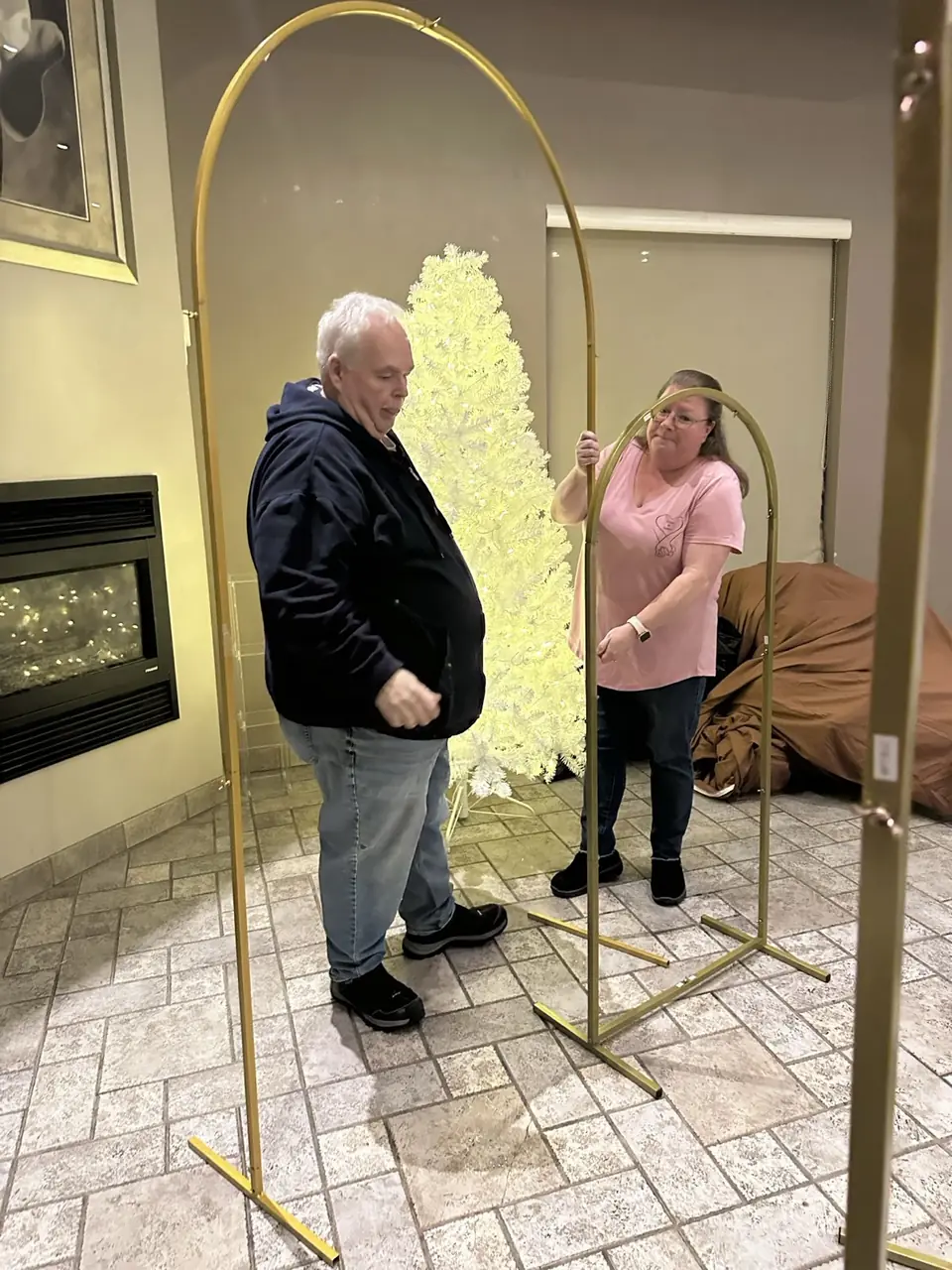 Cindy assembling gold arches for an event setup