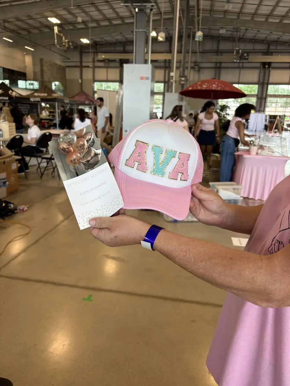 Custom pink trucker hat with chenille letters spelling AVA