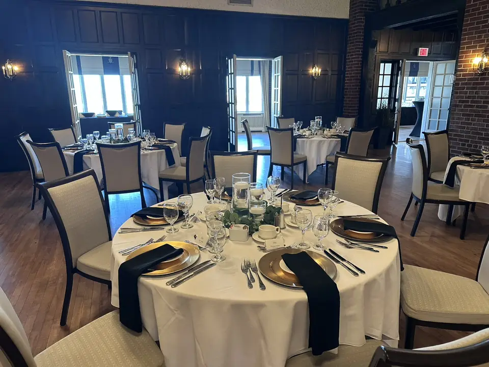 Reception table set with gold chargers, black napkins and a floating-candle centrepiece