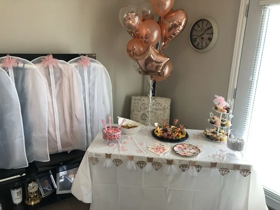 Bridal shower dessert table with rose-gold balloons