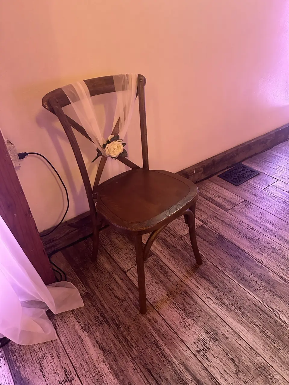 Cross-back chair with tulle sash and cream rose